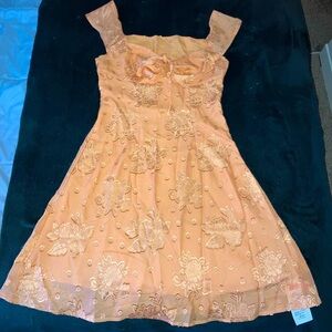 Floral design orange sun dress. Hidden side zipper and adjustable boob ties.